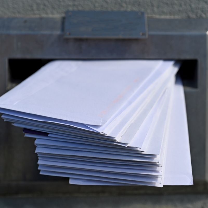 Buzón metálico lleno de cartas y sobres